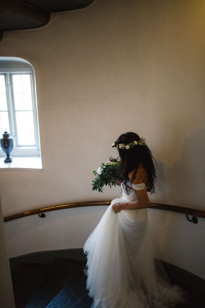 Bruden Ashley Ljungbäck går nedför trappan på Trolleholms slott. Brudklänning från Mia Grace Bridal, florist är Lilla Hults blommor. Fotograf Tove Lundquist i Skåne.