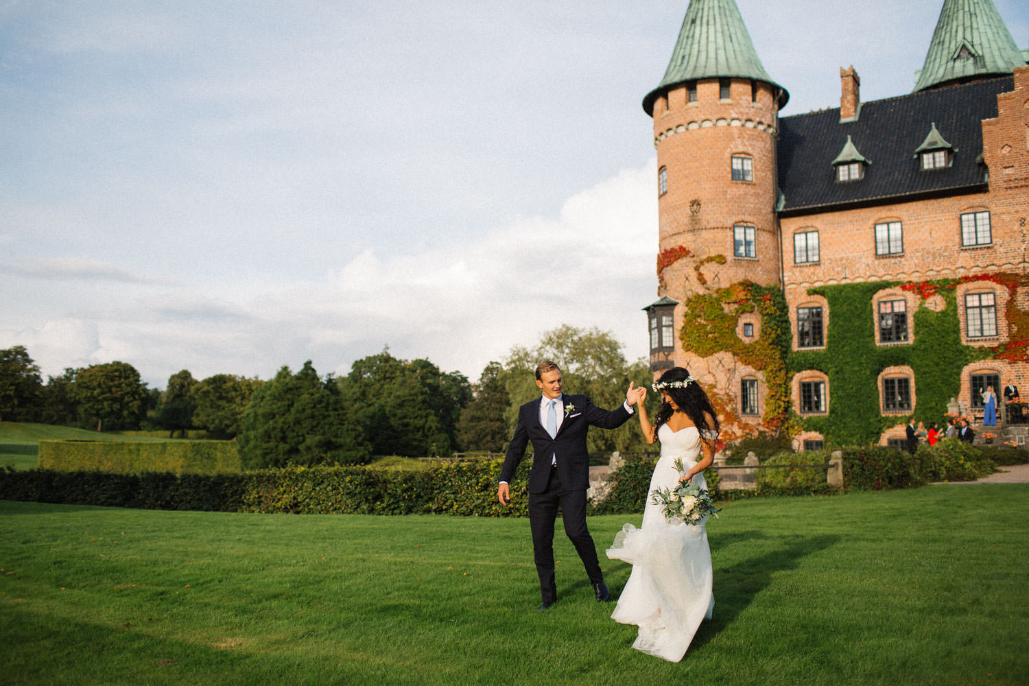 Brudpar går i Trolleholms slott trädgård, Skåne.