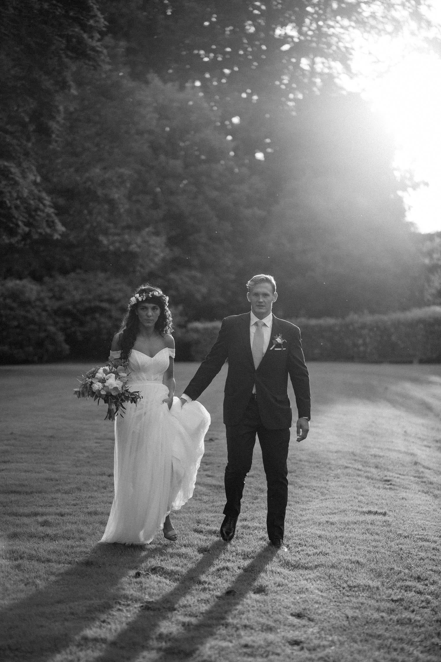 Svartvitt foto på gående brudpar under ett bröllop på Trolleholms slott i Skåne. Foto: Tove Lundquist, bröllopsfotograf i Malmö. 