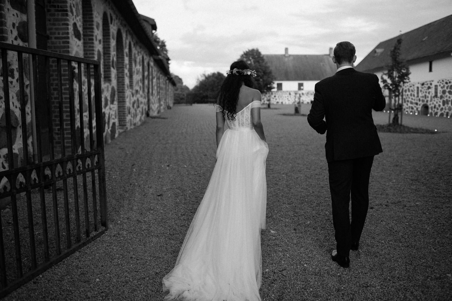 Svartvitt foto på gående brudpar på Trolleholms slott.
