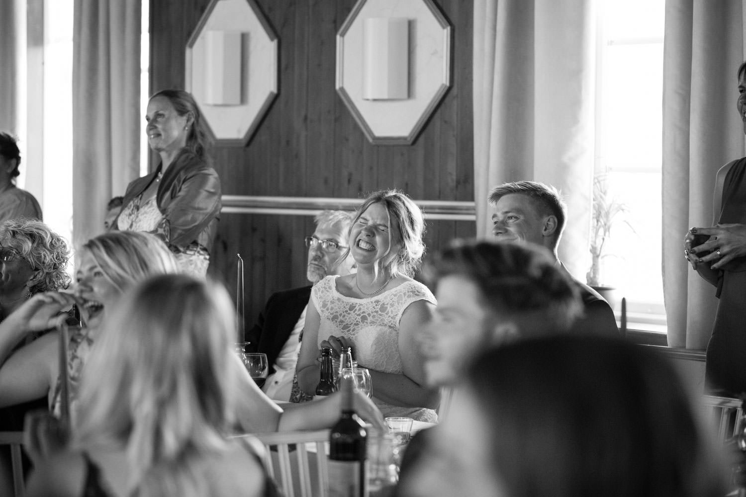 Brud skrattar under ett tal under ett bröllop på Torpalängan, Smygehamn. Foto: Tove Lundquist.
