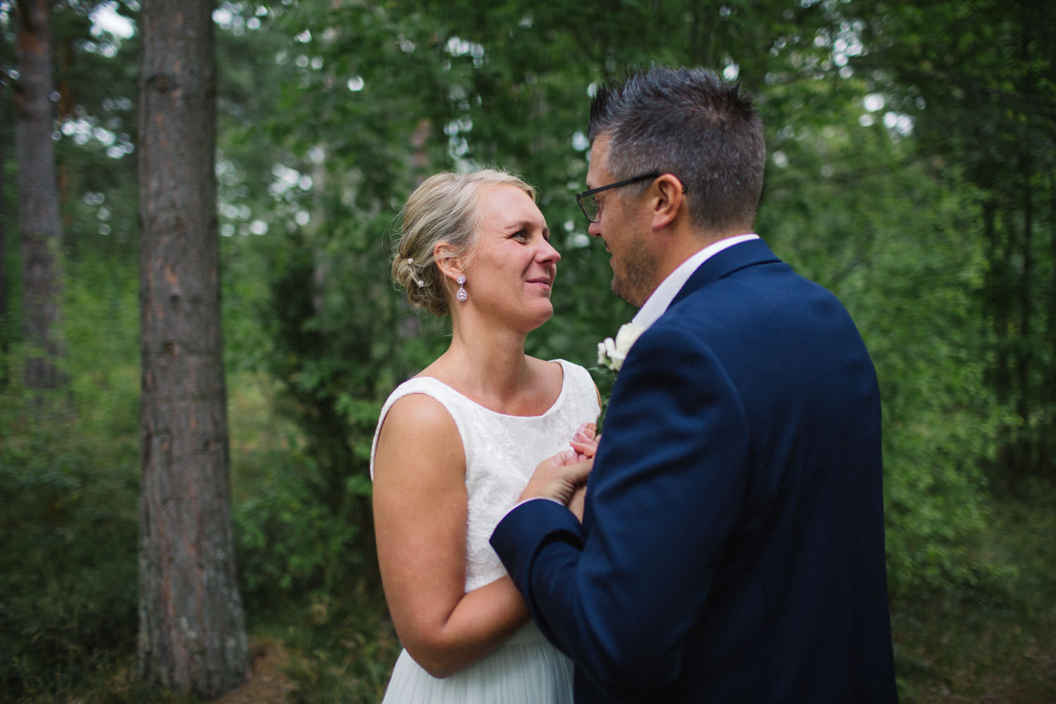 Avslappnat och naturligt bröllopsporträtt på brudpar vid Oknö. Kostym från Dressmann. Brudklänning från Sofia Moore.