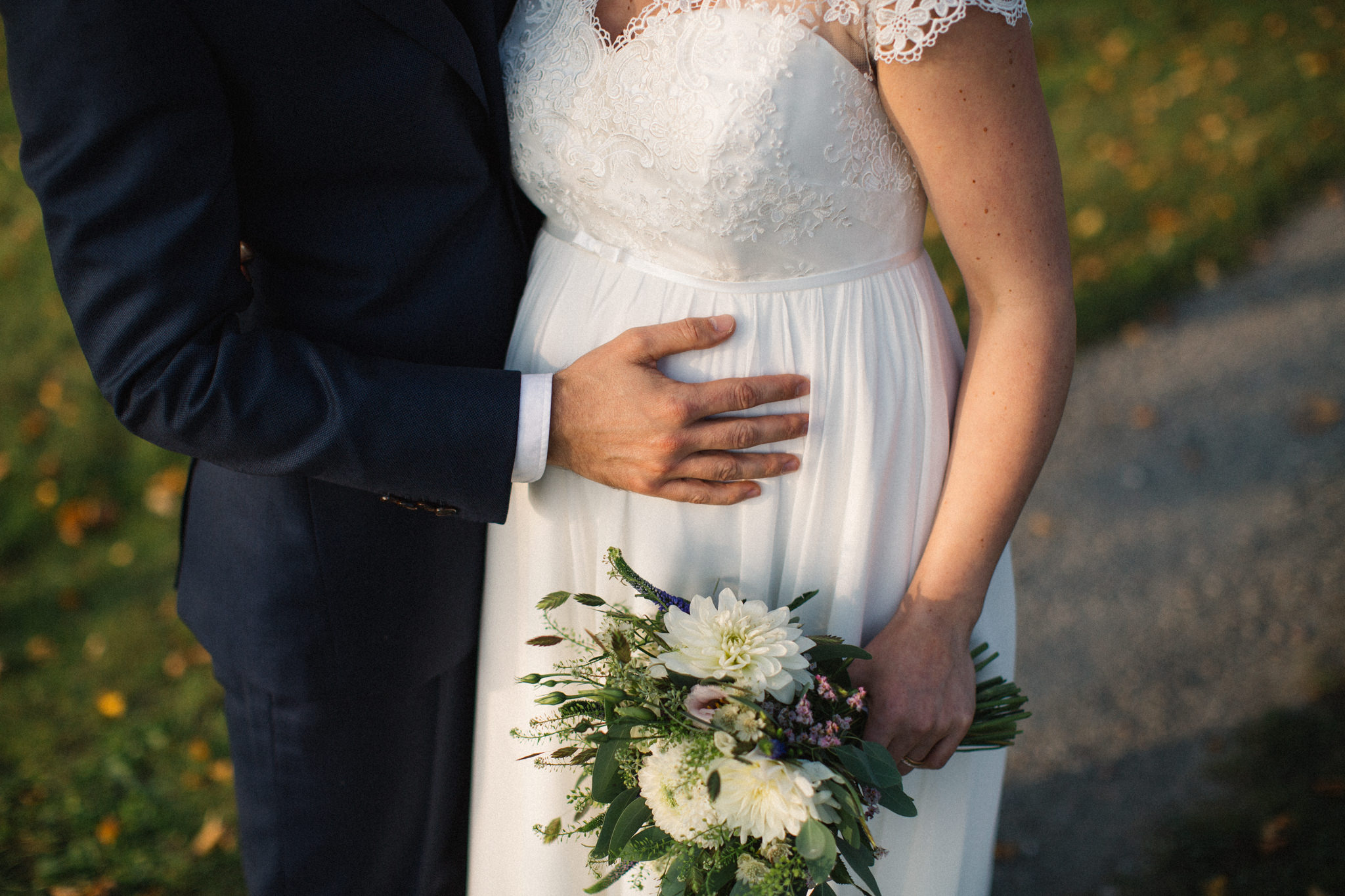 Brudgums hand på gravid brud, höstbröllopet ägde rum på ekogården Ängavallen i Skåne. Foto: Tove Lundquist.