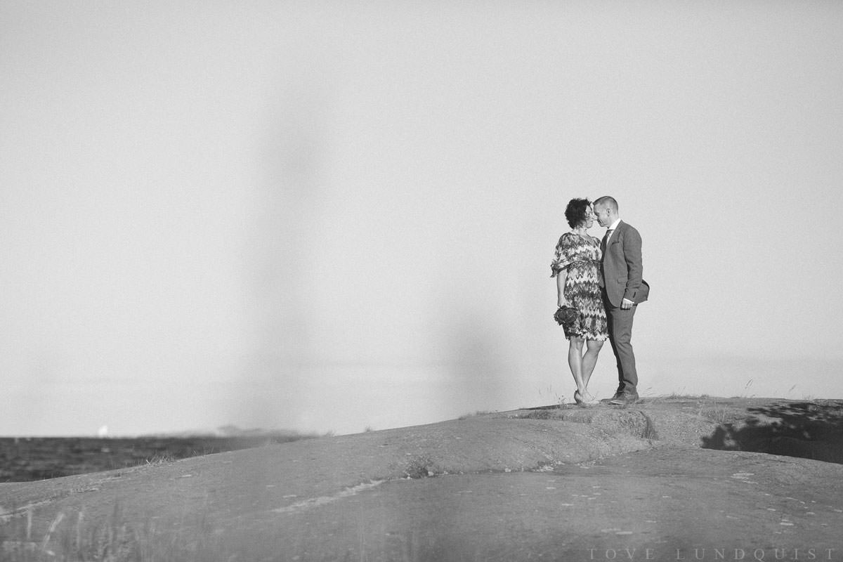 Svartvitt foto på brudpar som står på klipporna vid Ernemar Småbåtshamn, Oskarshamn.