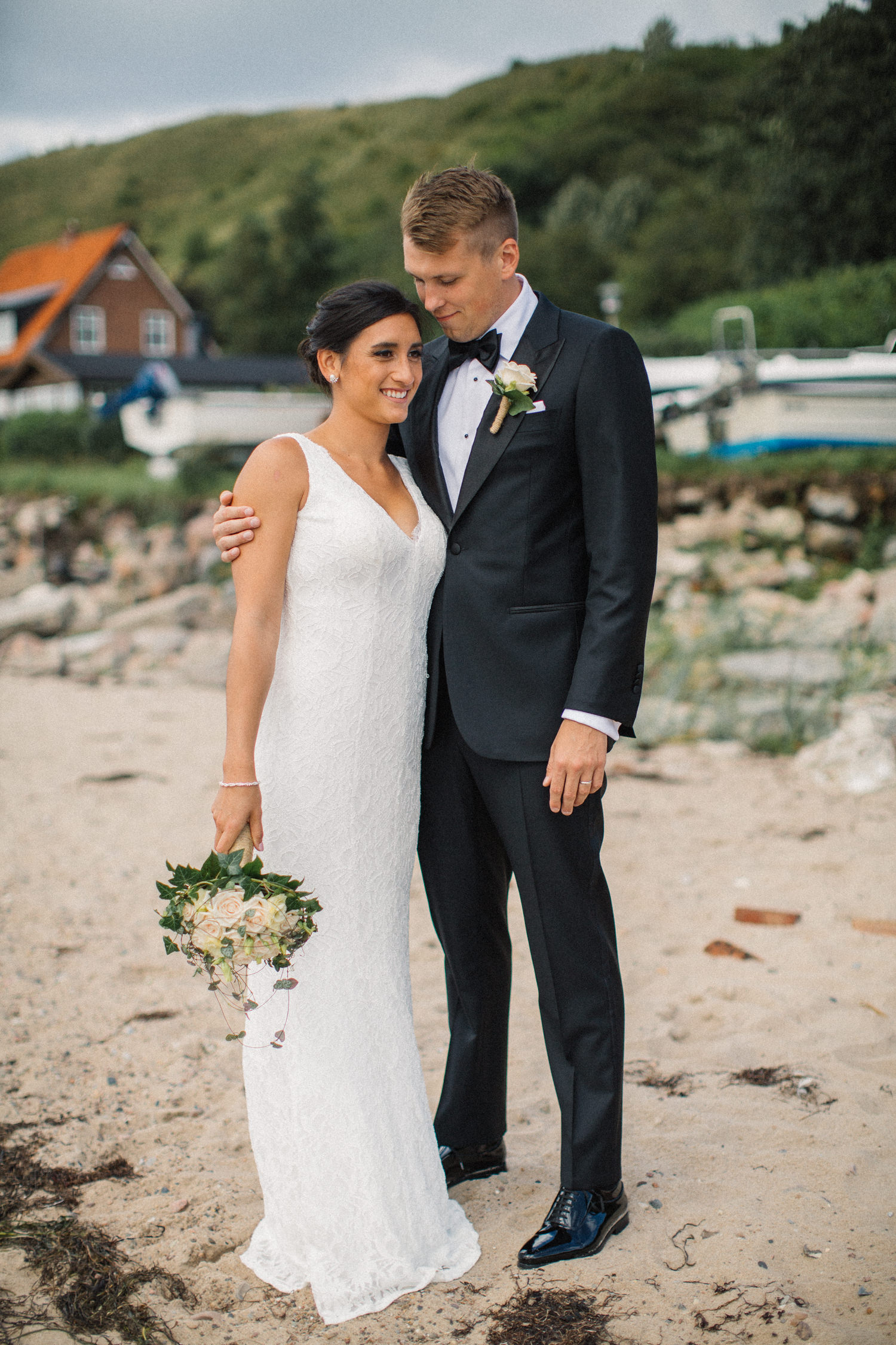 Internationellt svenskt-amerikanskt bröllop på Ven, porträtt på brud och brudgum på stranden. Klänning från DB Studio wedding dresses. Foto: Tove Lundquist.