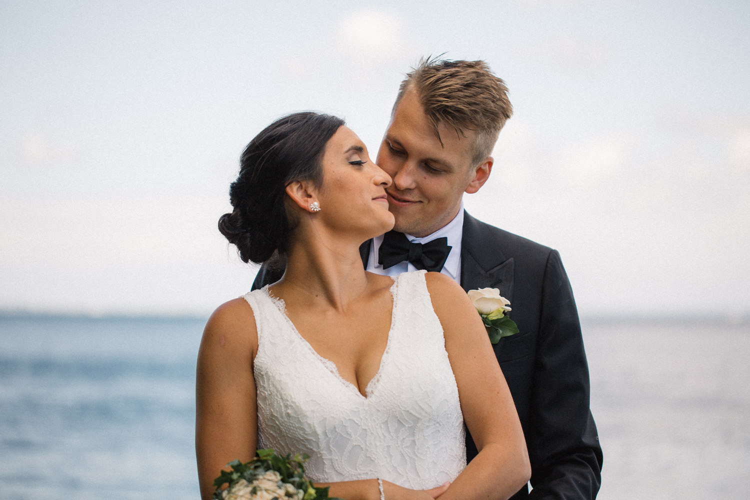 Internationellt svenskt-amerikanskt bröllop på Ven, porträtt på brudpar vid havet. Foto: Tove Lundquist.
