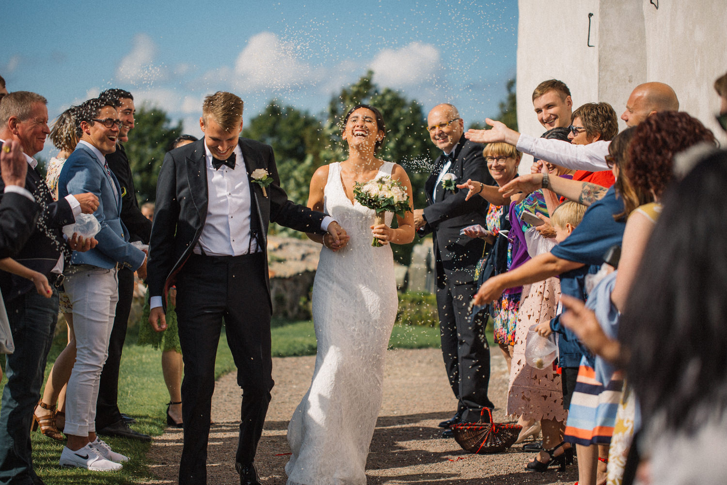 Riskastning under ett svenskt-amerikanskt bröllop på Ven, mingel utanför Sankt Ibbs kyrka efter vigselceremonin. Foto: Tove Lundquist, bröllopsfotograf i Skåne.