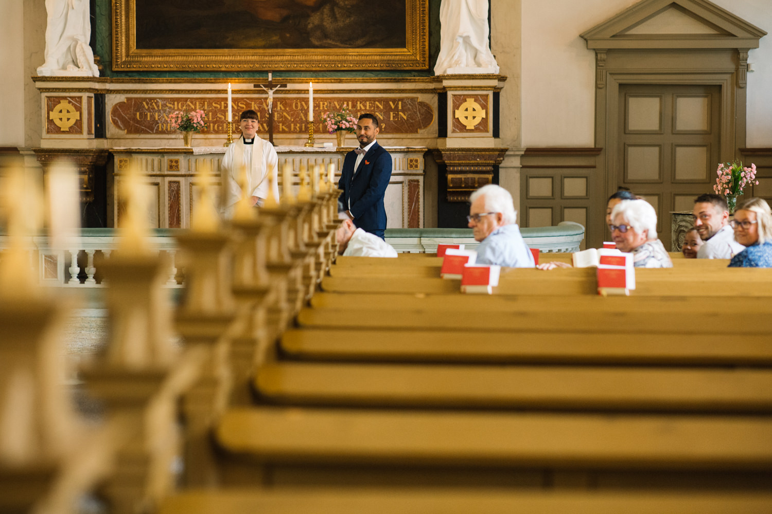 Vigsel i Sankta Maria kyrka, Borrby, brudgum väntar på bruden. Brudparet valde att ha ett mikrobröllop, en överraskning för bröllopsgästerna. Fotograf: Tove Lundquist.