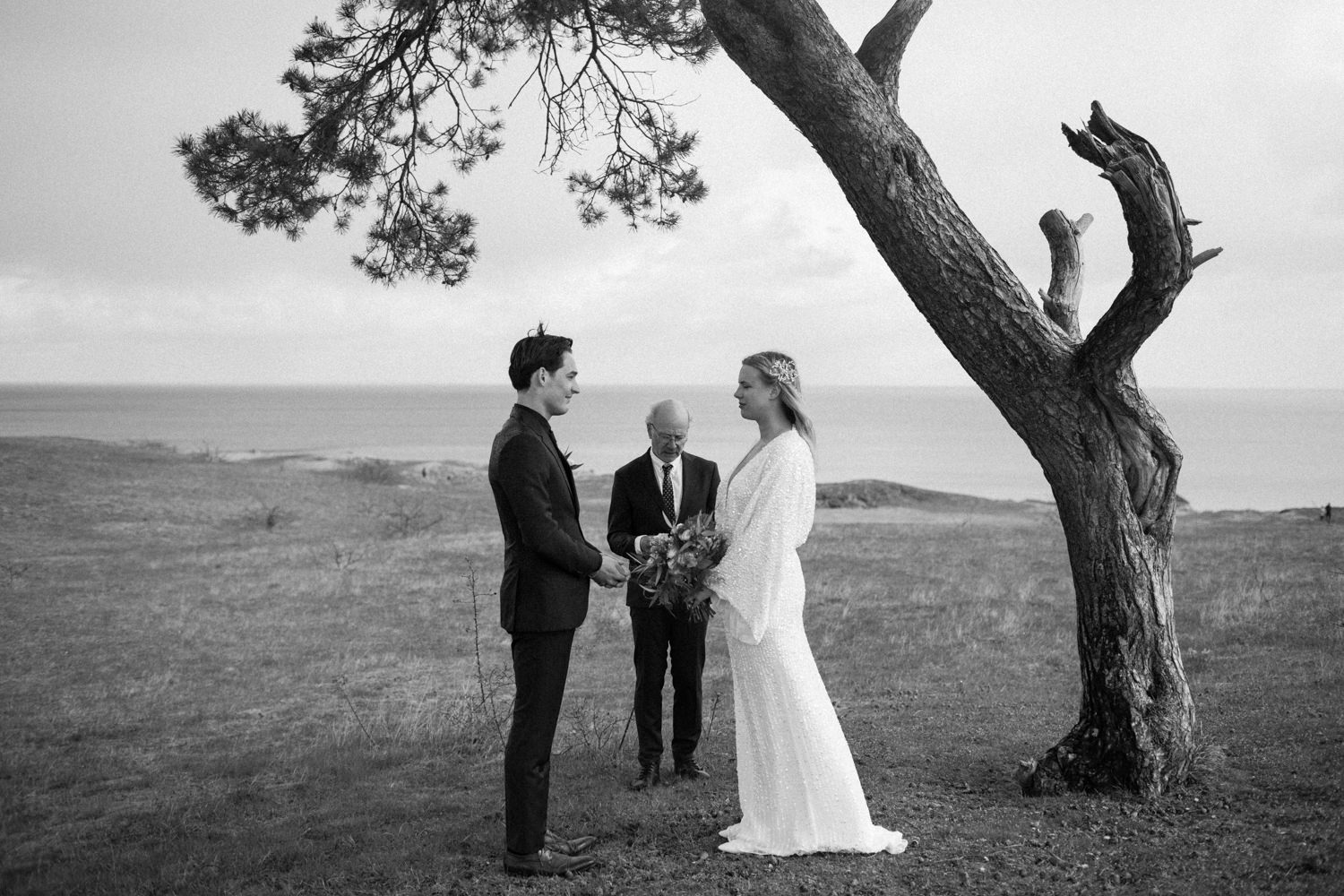 Foto på brudpar under ett elopement bröllop i Haväng, Skåne. Bilder från vigseln vid den ensamma tallen. Fotograf: Tove Lundquist.