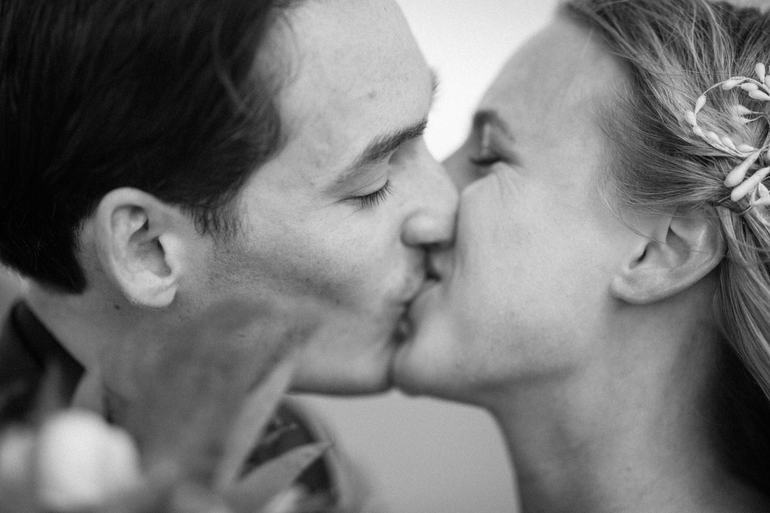 Foto på brudpar under ett elopement bröllop i Haväng, Skåne. Bilder från kyssen under vigseln vid den ensamma tallen. Fotograf: Tove Lundquist.