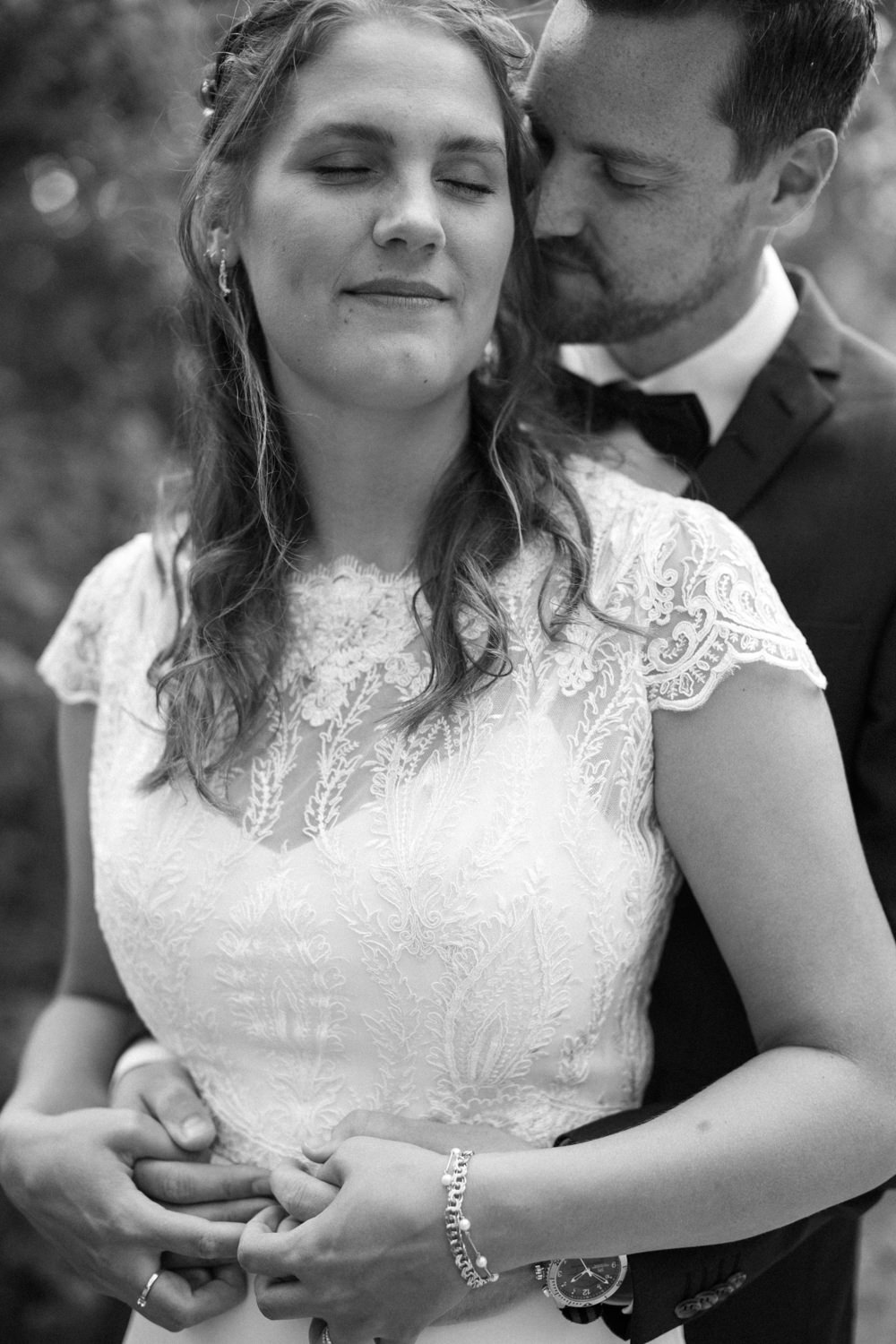 Svartvitt fotografi på ett kramande och kärleksfullt brudpar under ett bröllop i Skåne. Foto: Tove Lundquist, bröllopsfotograf i Malmö.