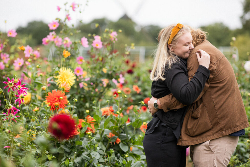 En parfotografering i Slottsträdgården i september månad, de starka färgerna på blommorna gav en somrig känsla till fotograferingen inför bröllopet. I bakgrunden ses Slottsmöllan vid Malmö Museer. Foto: Tove Lundquist, bröllopsfotograf i Malmö.