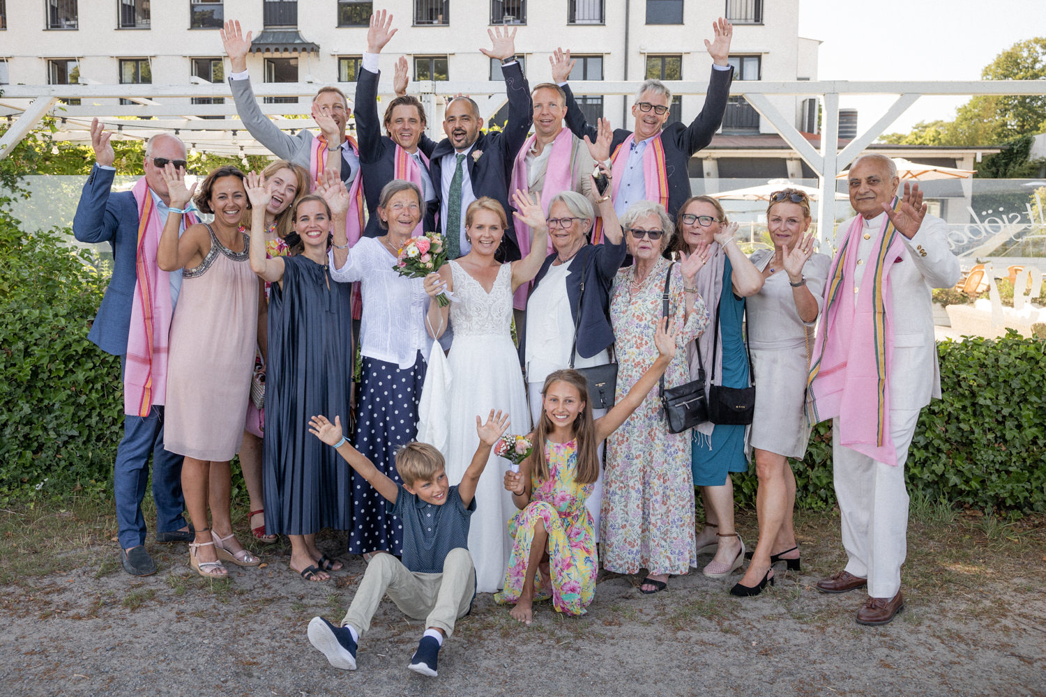 Gruppbild på brudpar med närmaste släkten under ett svenskt-indiskt strandbröllop på YSB, Skåne. Foto: Tove Lundquist, bröllopsfotograf i Skåne.
