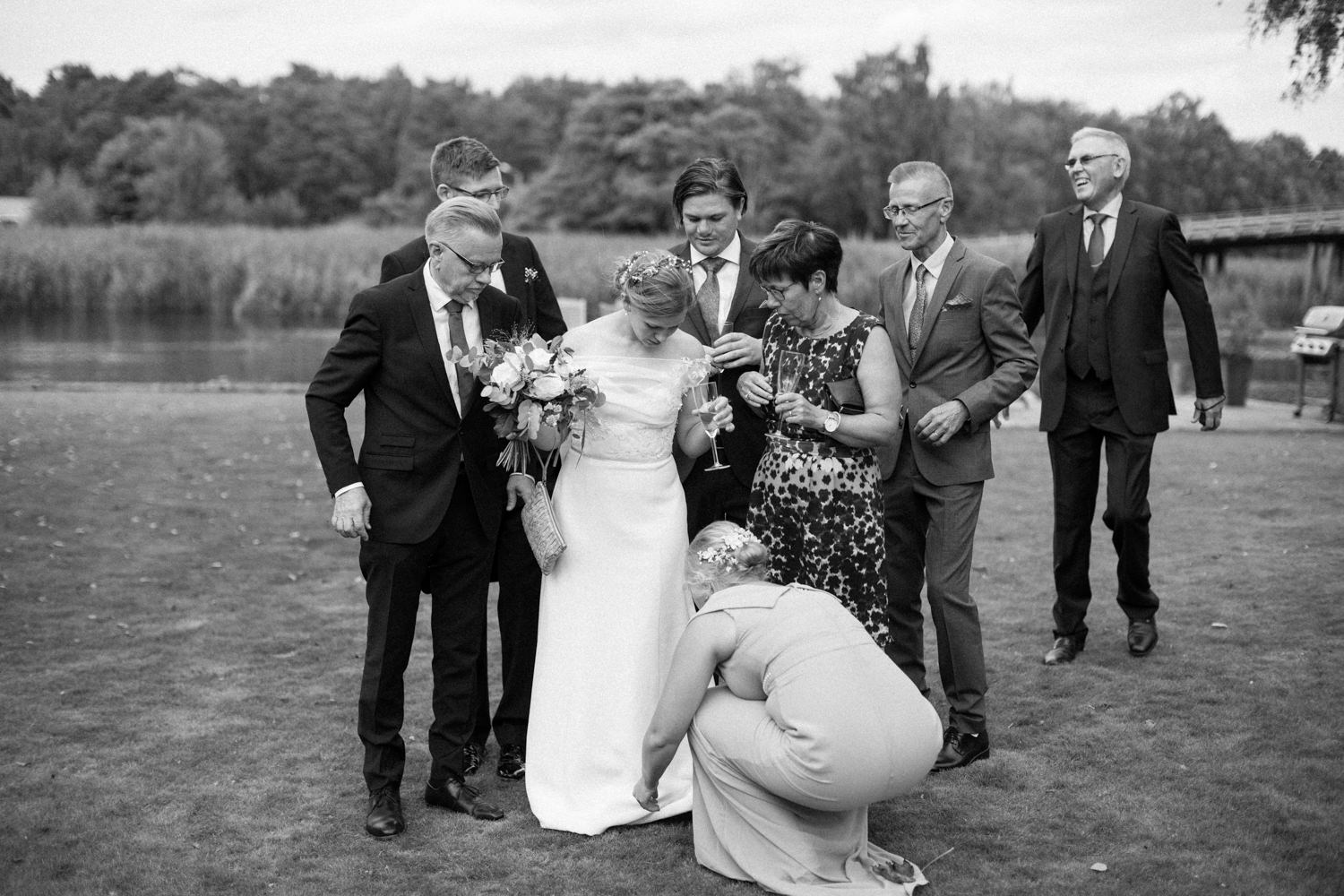 Dokumentärt svartvitt fotografi från grupporträtt under ett bröllop i Skåne. 