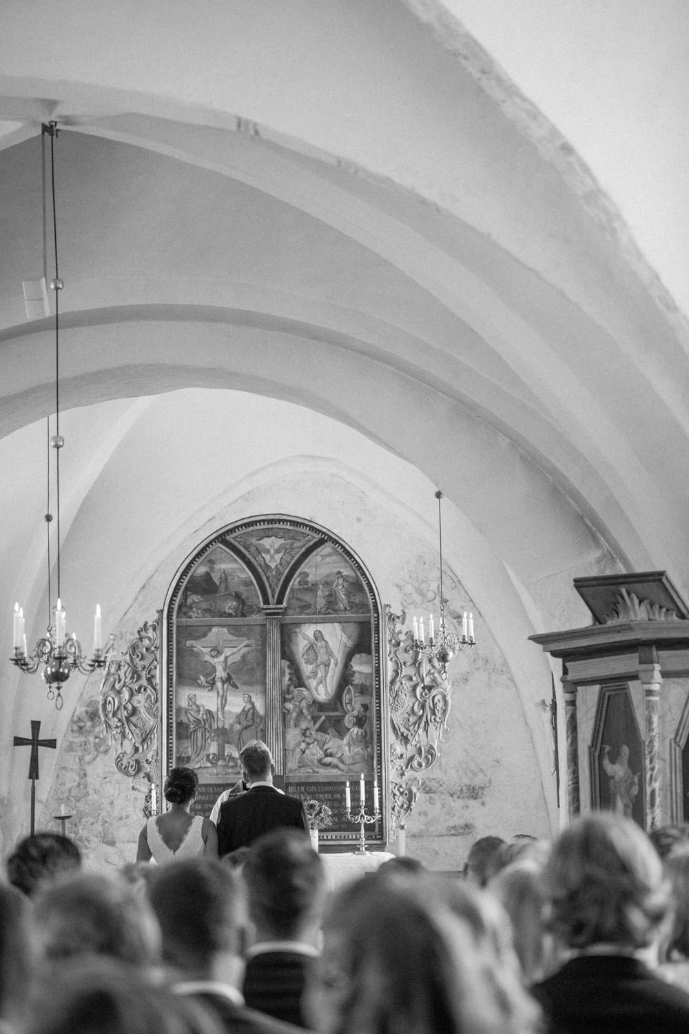 Svartvitt fotografi från en vigsel i Sankt Ibbs kyrka på Ven under ett svenskt-amerikanskt destinationsbröllop. Fotograf är Tove Lundquist.